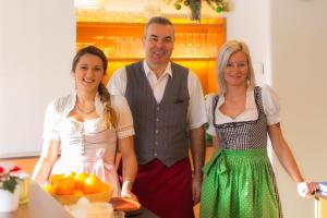 a man and two women standing in a kitchen at Belvedere in Semmering