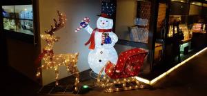 a snowman and a reindeer in a store window at I-more Motel in Yonghe +70 photos