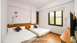 a bedroom with two beds and a tv in it at Green Garden in Xiaoliuqiu