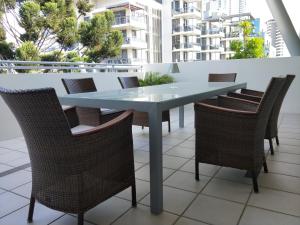 una mesa azul y sillas en el balcón en Trilogy Surfers Paradise, en Gold Coast