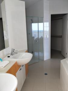 a bathroom with a glass shower and a sink at Trilogy Surfers Paradise in Gold Coast