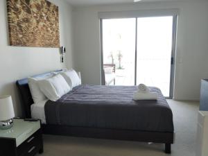 Trilogy Surfers Paradise في غولد كوست: غرفة نوم بسرير ونافذة كبيرة