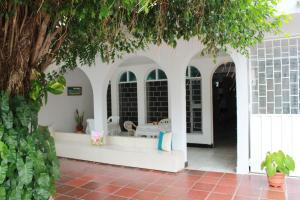 a porch with white arches and a table and chairs at Aqui me quedo in Cartagena de Indias