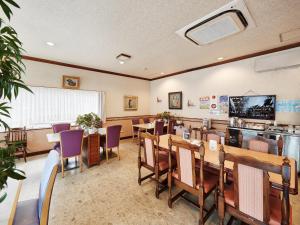 a dining room with tables and purple chairs at Crown Hotel Okinawa in Okinawa City