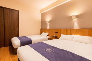 pokój hotelowy z 2 łóżkami w pokoju w obiekcie LAPIN MIHAMA Residence Hotel w mieście Chatan