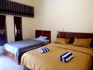 Duas camas sentadas uma ao lado da outra num quarto em Golo Tango Homestay em Labuan Bajo