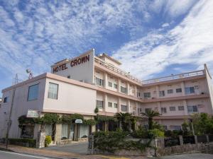 a hotel building with a sign on top of it at Crown Hotel Okinawa in Okinawa City