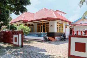 巴東的住宿－Wisma Mutiara，一座红色屋顶和门的房子