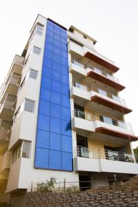 a tall apartment building with blue glass windows at Hotel Park Riviera in Guwahati