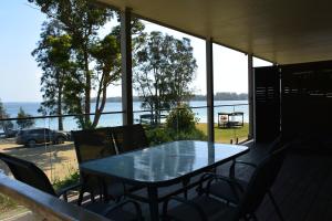 a dining room table with a view of the ocean at Dungowan Holiday Accommodation in Erowal Bay