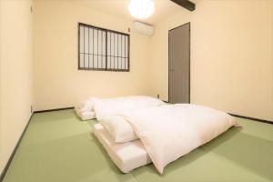 福岡市にあるMUSUBI HOTEL MACHIYA Haruyoshiの緑の床の客室内の白いベッド2台 +56枚の写真