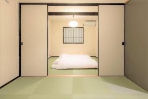 福岡市にあるMUSUBI HOTEL MACHIYA Haruyoshiのスライドドアを通してベッド付きの部屋