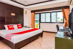 a bedroom with a large bed and a desk at OYO 447 Royal Express Hua Hin in Hua Hin