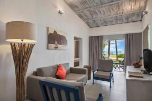 a living room with a couch and a table and chairs at Astroea Beach Hotel in Mahébourg