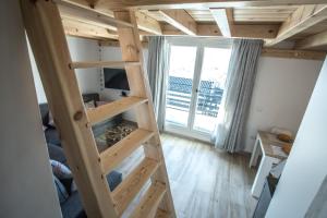 ein Hochbett mit einer Leiter in einem Zimmer mit einem Fenster in der Unterkunft MULHACEN in Sierra Nevada