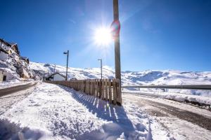 eine schneebedeckte Straße mit der Sonne am Himmel in der Unterkunft MULHACEN in Sierra Nevada
