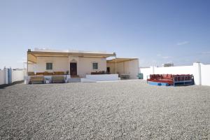 a house sitting on top of a gravel lot at Ras Al Hadd Orchid in Al Ḩadd