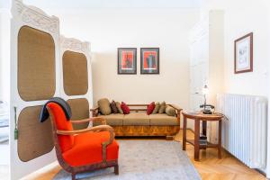 uma sala de estar com um sofá e uma cadeira vermelha em Stunning spacious art nouveau apart , grand piano em Budapeste