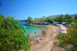 a beach with a bunch of people in the water at דאוס האוס - דירות אירוח מודרניות ושקטות in Eilat