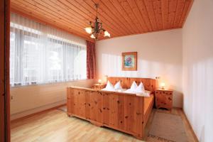 エルマウにあるHaus Friederike - Sylvia Brunnerのベッドルーム(木製ベッド1台、大きな窓付)