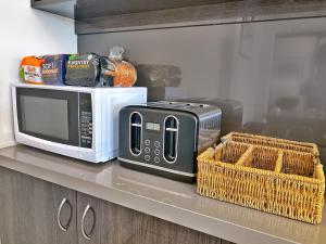 a microwave and baskets on a counter in a kitchen at Commercial Motel in Hay +21 photos