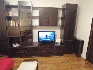 a black entertainment center with a television in a living room at Apartament Athenee Palace Bucharest in Bucharest