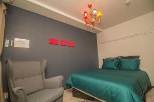 sypialnia z łóżkiem, krzesłem i żyrandolem w obiekcie Nakayoshi Stay 401 w Osace