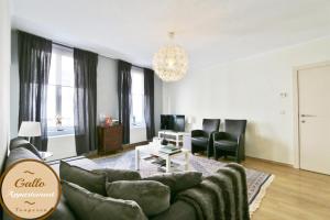 un soggiorno con divano, sedie e lampadario pendente di Gallo Appartement & Duplex Tongeren centrum a Tongeren