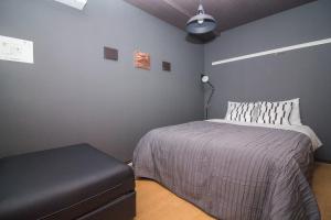 um quarto com uma cama e um repousa-pés em Nakayoshi Stay 201 em Osaka