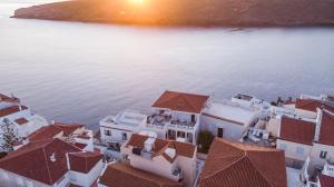 an aerial view of a group of white buildings by the water at CAMARA SUITES in Andros
