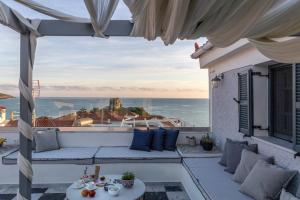 a patio with a couch and a view of the ocean at CAMARA SUITES in Andros
