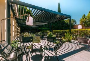 a patio with chairs and a pergola at Escale Oceania Aix-en-Provence in Aix-en-Provence