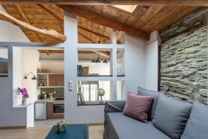 sala de estar con sofá azul y pared de piedra en CAMARA SUITES, en Ándros