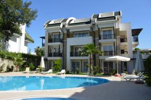 a building with a swimming pool in front of a building at Sultan Homes Apartments 2 in Kemer
