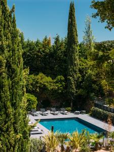 a swimming pool in a garden with trees at Escale Oceania Aix-en-Provence in Aix-en-Provence