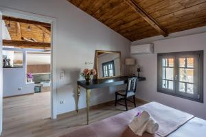 a bedroom with a desk and a mirror at CAMARA SUITES in Andros