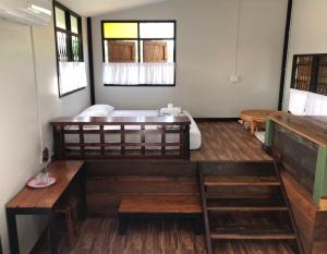 a room with a tub and wooden floors and windows at BAANYA HOMESTAY Ko Kret in Nonthaburi