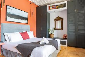 a bedroom with a large bed and an orange wall at CAMARA SUITES in Andros