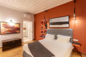 a bedroom with a large bed and a tv on the wall at CAMARA SUITES in Andros