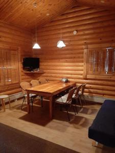 een houten eetkamer met een houten tafel en stoelen bij Pankkotupa 65 "13А" in Savonlinna