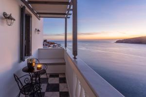 a balcony with a table and a view of the ocean at CAMARA SUITES in Andros