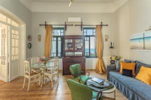 a living room with a blue couch and a table at CAMARA SUITES in Andros
