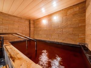una grande piscina d'acqua in una parete di legno di Hotel Grand Terrace Obihiro a Obihiro