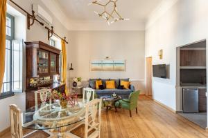 a living room with a blue couch and a glass table at CAMARA SUITES in Andros