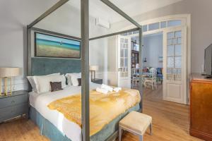 a bedroom with a canopy bed with a view of the ocean at CAMARA SUITES in Andros