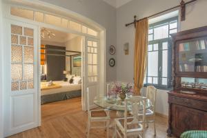 a dining room with a table and a bedroom at CAMARA SUITES in Andros
