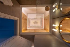 a bathroom with a window and a mirror at CAMARA SUITES in Andros