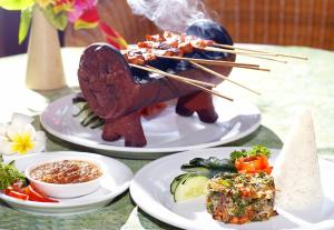 two plates of food on a table with chopsticks at Santai Hotel in Amed