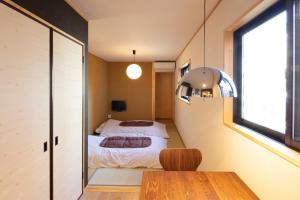 Cette petite chambre comprend deux lits et une table. dans l'établissement カモンイン 東寺道, à Kyoto