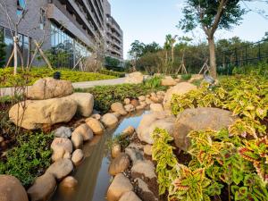 a garden with rocks and a stream of water at Fame Hall Garden Hotel in Longtan